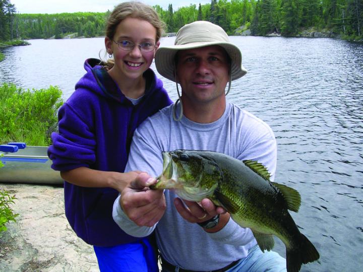 Father and daughter show off fish they caught