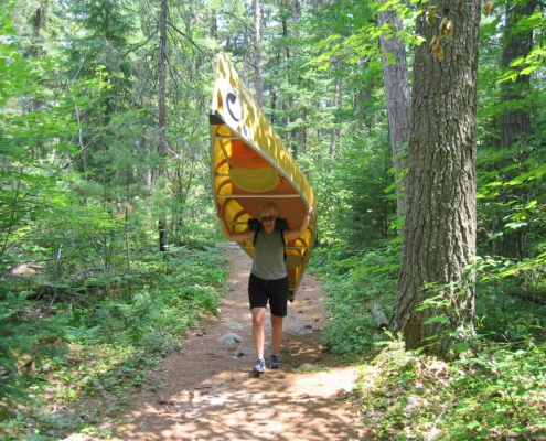 woman carrying canoe over her head